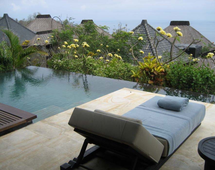 Poolside daybed among tropical planting
