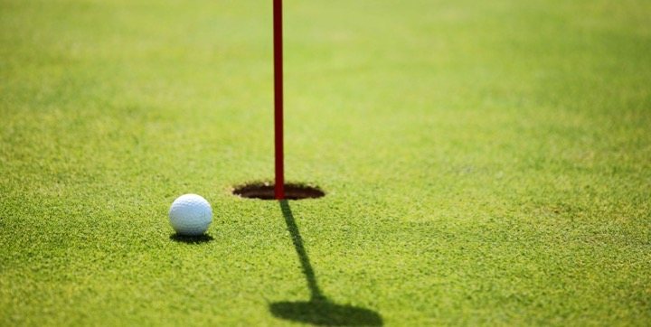 Golf ball beside the hole on a manicured green